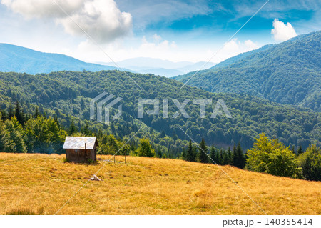 view of mountain meadow at noon. countryside summertime landscape with beech forest on the grassy field on hill. fluffy clouds on a bright blue sky. alpine background for travel through highland view of mountain meadow at noon. countryside summertime landscape with beech forest on the grassy field on hill. fluffy clouds on a bright blue sky. alpine background for travel through highland 140355414