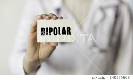 Bipolar. Doctor holds a card with the text which means bipolar disorder 140355668