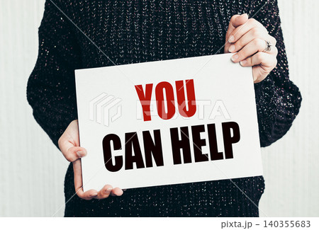 Girl holding a card with text you can help 140355683