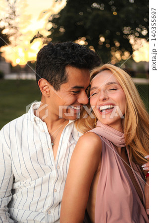 Joyful couple enjoying a sunset together in the park Joyful couple enjoying a sunset together in the park 140355697