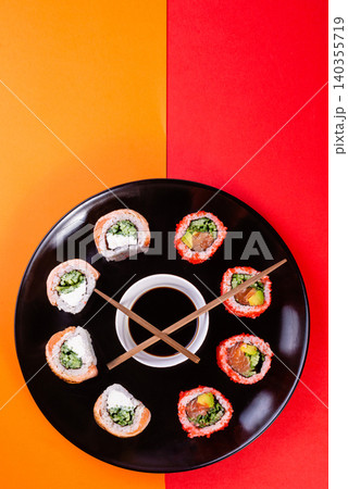 Creative flat lay of assorted sushi rolls on circle plate over red background Creative flat lay of assorted sushi rolls on circle plate over red background 140355719