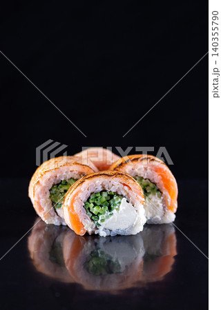 Close up of premium philadelphia salmon rolls with cream cheese on dark reflective surface Close up of premium philadelphia salmon rolls with cream cheese on dark reflective surface 140355790