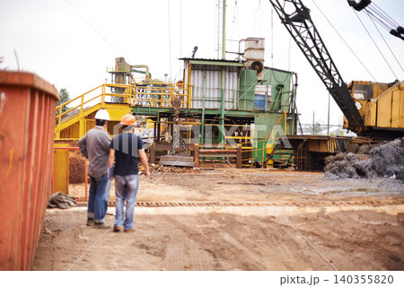 Crane, machine and engineer men in scrapyard to recycle metal for sustainability, manufacturing or pollution. Vehicle, people and outdoor in junkyard for ecology with back, industry and environment 140355820