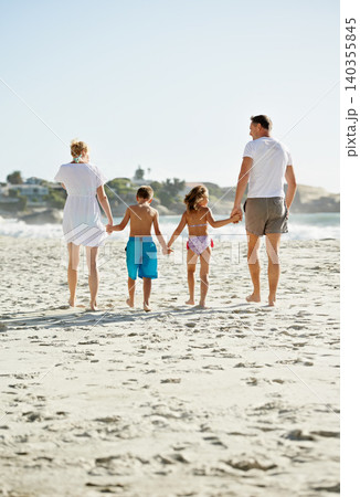 Parents, children and hand holding on beach for holiday together at ocean for connection, bonding or travel. Man, woman and siblings with back view at sea in Florida for vacation, outdoor or journey 140355845
