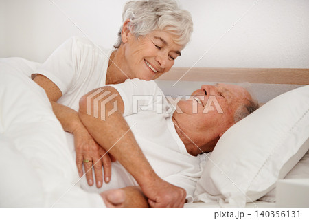 Senior couple, hug and communication in bed, relaxing and love in retirement for bonding on weekend. Happy elderly people, conversation and embracing in marriage, romance and morning routine at home 140356131