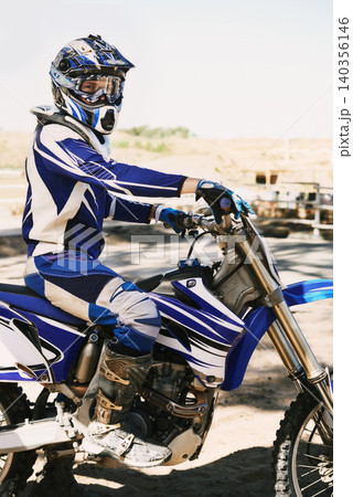 Motorcycle, extreme sport and portrait for person on trail for competition, race or games with speed. Racer, motorbike and helmet for contest, motor cross and fast transport with sunshine in desert Motorcycle, extreme sport and portrait for person on trail for competition, race or games with speed. Racer, motorbike and helmet for contest, motor cross and fast transport with sunshine in desert 140356146