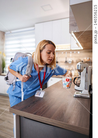 Nurse preparing coffee before work in the kitchen 140356215