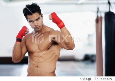 Portrait, man and boxer in gym for sports, training or competition for body health. Fighter, athlete and serious person with muscle on abs for fitness, exercise and martial arts at club in Brazil Portrait, man and boxer in gym for sports, training or competition for body health. Fighter, athlete and serious person with muscle on abs for fitness, exercise and martial arts at club in Brazil 140356389