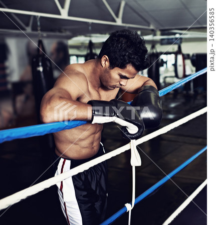 Sports, break and man boxer in gym for exercise, workout and combat training for competition. Breathing, health and shirtless male athlete fighter in boxing ring with gloves in fitness center. Sports, break and man boxer in gym for exercise, workout and combat training for competition. Breathing, health and shirtless male athlete fighter in boxing ring with gloves in fitness center. 140356585