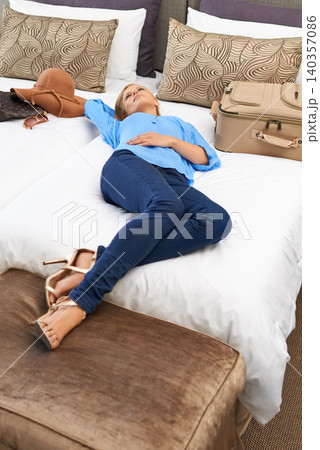 Woman, hotel room and bed relax with suitcase for travel holiday or accommodation, vacation or weekend. Female person, lying and tourist hospitality in Miami for packing luggage, comfortable or rest Woman, hotel room and bed relax with suitcase for travel holiday or accommodation, vacation or weekend. Female person, lying and tourist hospitality in Miami for packing luggage, comfortable or rest 140357086