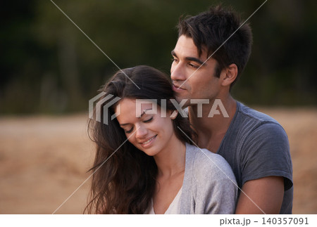 Couple, relax and embrace outdoor with love in nature on holiday or vacation in summer. People, smile and calm moment together on date or travel in Florida to beach and hug partner with gratitude 140357091