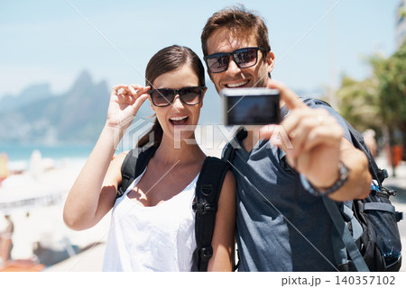 Couple, beach and camera for selfie on vacation with smile, sunglasses and outdoor for memory in summer. People, man and woman with photography by ocean for journey, vacation and sunshine in Italy Couple, beach and camera for selfie on vacation with smile, sunglasses and outdoor for memory in summer. People, man and woman with photography by ocean for journey, vacation and sunshine in Italy 140357102