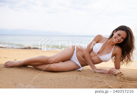 Bikini, beach and portrait of woman relaxing on sand on tropical vacation, adventure or holiday. Smile, nature and female person in swimsuit laying by ocean or sea for island travel or weekend trip. Bikini, beach and portrait of woman relaxing on sand on tropical vacation, adventure or holiday. Smile, nature and female person in swimsuit laying by ocean or sea for island travel or weekend trip. 140357210