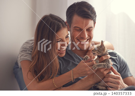 Couple, kitten and smile in home on sofa with hug for love, bonding or care for pet in living room. People, man and woman with kindness, embrace and excited for baby cat in lounge for animal adoption Couple, kitten and smile in home on sofa with hug for love, bonding or care for pet in living room. People, man and woman with kindness, embrace and excited for baby cat in lounge for animal adoption 140357333
