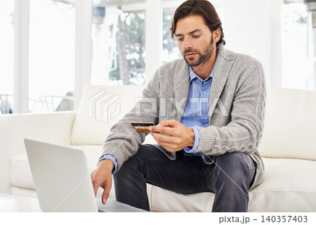 Man, laptop and home with credit card on banking, app and online shopping with discount and sale on delivery. Leisure, couch and living room on website for break, spend and payment on order. Man, laptop and home with credit card on banking, app and online shopping with discount and sale on delivery. Leisure, couch and living room on website for break, spend and payment on order. 140357403
