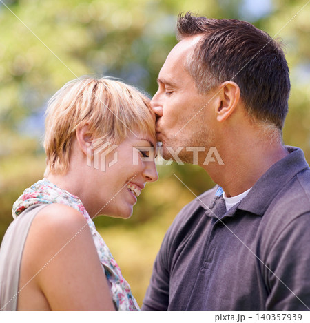 Couple, love and kiss on forehead with happiness in outdoor, affection and romance with date. Closeup, relationship and together with smile for bonding, care and trust with commitment for support 140357939
