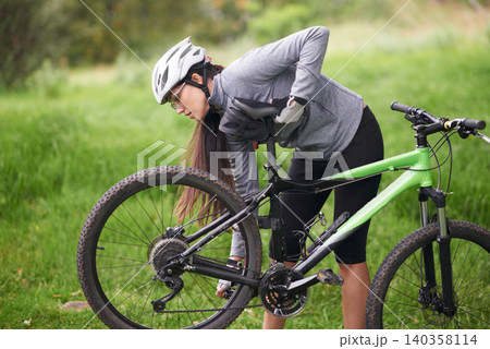 Fitness, bike and flat wheel with woman cyclist in countryside for sports, hobby or cardio training. Exercise, cycling or tyre puncture with young athlete fixing bicycle outdoor in nature for workout 140358114