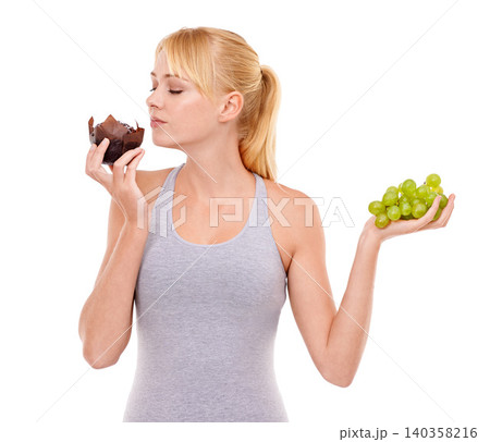 Woman, temptation and dessert over fruit in studio with white background in backdrop. Girl, choice and decision between muffin or grapes for nutrition in food, think and care for wellness of body Woman, temptation and dessert over fruit in studio with white background in backdrop. Girl, choice and decision between muffin or grapes for nutrition in food, think and care for wellness of body 140358216