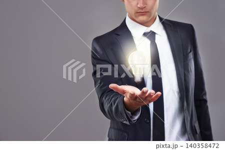 Business man, light bulb glow and ideas for entrepreneur with innovation and problem solving for energy saving. Hologram, solution and corporate goals for knowledge and power on grey background Business man, light bulb glow and ideas for entrepreneur with innovation and problem solving for energy saving. Hologram, solution and corporate goals for knowledge and power on grey background 140358472