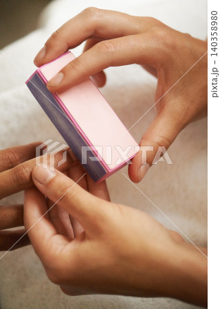 Hands, manicure and buffing nails in salon for beauty treatment, relax or care. Closeup, spa or tool on fingernail for polish at cosmetic service with professional, customer and cleaning for wellness 140358980