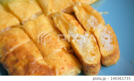 roll omelette stuffed with chesse and rice on blue plate, delicious food in the morning roll omelette stuffed with chesse and rice on blue plate, delicious food in the morning 140361735