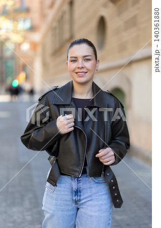Young woman walks along city street 140361880
