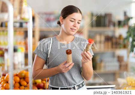 Young woman choosing seasoning herbs in grocery Young woman choosing seasoning herbs in grocery 140361921