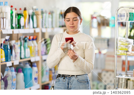 Woman scanning tin cans on her phone 140362095