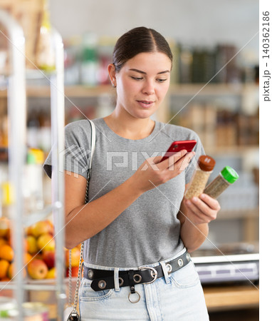 Young woman scanning qr code for seasoning herbs Young woman scanning qr code for seasoning herbs 140362186