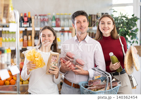 of man and woman with girl choosing food in grocery 140362454