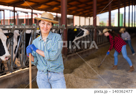 Young adult woman farmer working in cowshed Young adult woman farmer working in cowshed 140362477