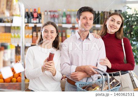 of man and woman with girl choosing food in grocery of man and woman with girl choosing food in grocery 140362531