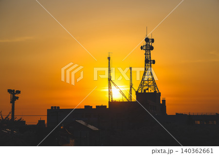 April 25 2026 Urban Communication Towers Silhouette Against Golden Sunset 140362661