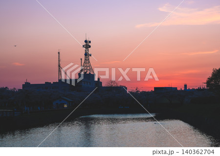 April 25 2026 Urban Communication Towers Silhouetted Against Colorful Sunset 140362704