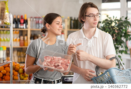 man and woman choosing lamb in grocery man and woman choosing lamb in grocery 140362772