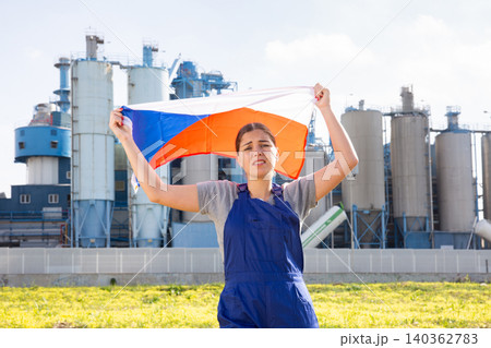 Sad young woman near factory with Czech Republic flag Sad young woman near factory with Czech Republic flag 140362783
