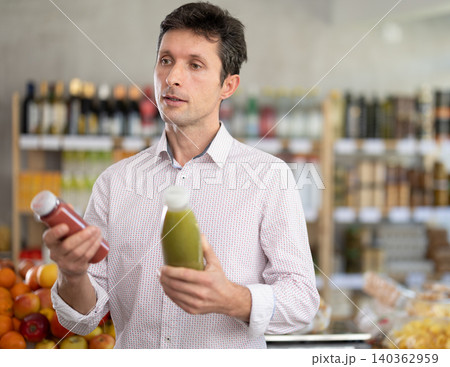 Man chooses a smoothie Man chooses a smoothie 140362959