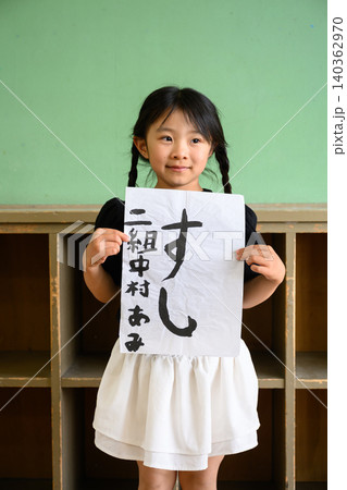 教室の後ろで笑顔で「すし」の習字作品を見せる女子小学生 教室の後ろで笑顔で「すし」の習字作品を見せる女子小学生 140362970