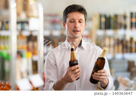 Adult man choosing beer in grocery store Adult man choosing beer in grocery store 140363647