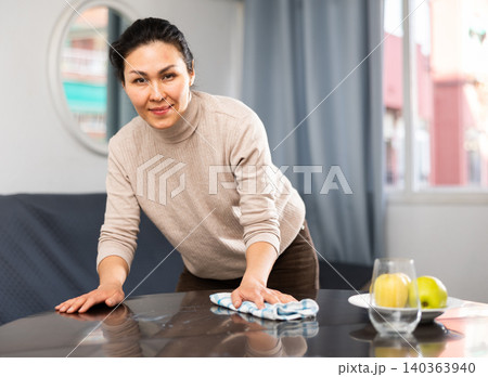 Woman washing table during cleanup 140363940