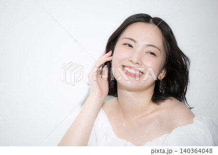 風になびく髪と透明感のある笑顔が美しい若い女性のスキンケアやヘアケアビューティーイメージ見上げる 風になびく髪と透明感のある笑顔が美しい若い女性のスキンケアやヘアケアビューティーイメージ見上げる 140364048