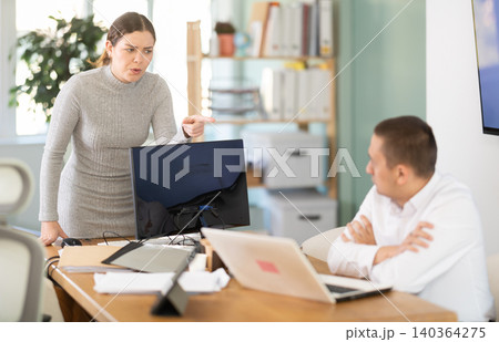 Young woman scolds adult man in office 140364275
