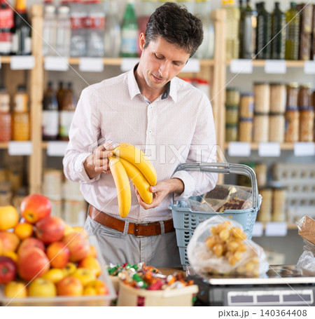 man chooses bananas 140364408