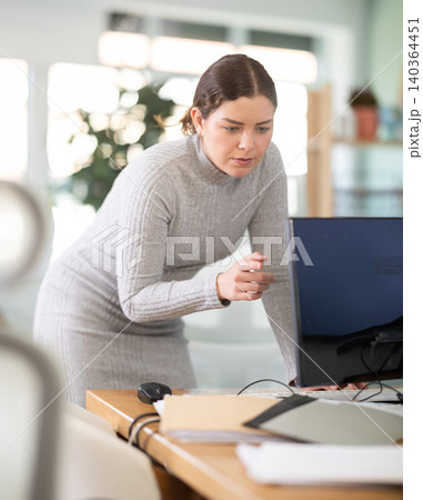 Young woman works at computer in office Young woman works at computer in office 140364451