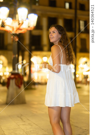 In night, young smiling girl walks along city street Placa Real In night, young smiling girl walks along city street Placa Real 140364521
