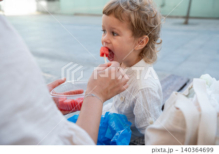 Toddler Eating Watermelon Snack From Caregiver Outdoors 140364699