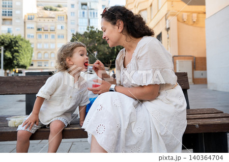 Little Child Eating Watermelon From Parent in Summer Little Child Eating Watermelon From Parent in Summer 140364704