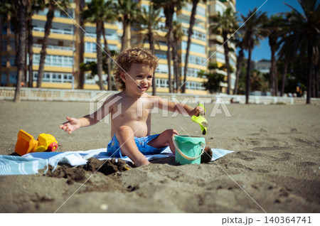 Toddler Playing With Sand Bucket on Sunny Beach 140364741