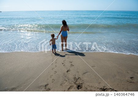 Mother and Toddler Holding Hands at Ocean Shoreline Mother and Toddler Holding Hands at Ocean Shoreline 140364746