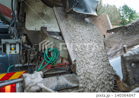 Mixer truck pouring concrete on a roadworks construction site in England for paving and repairs 140364847